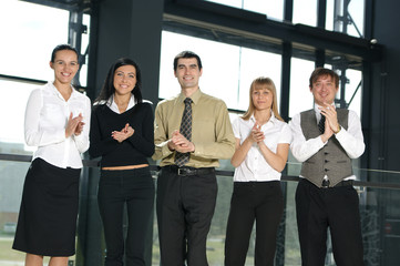 A group of five young business persons in a modern office