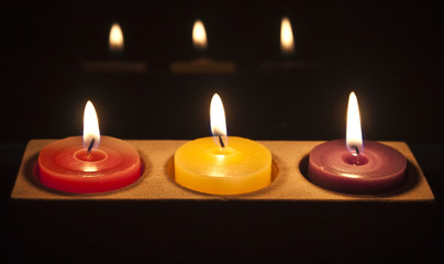 red, yellow and purple candles in a row