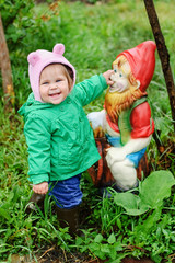 Fototapeta premium girl holding the nose of garden gnome