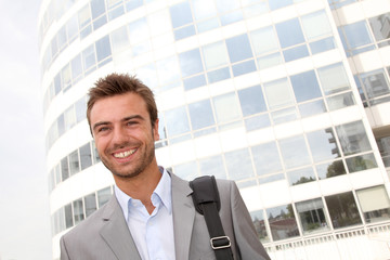 Closeup of businessman standing in front of offices building