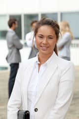 Closeup of young businesswoman standing in front of a group