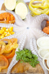 Octopus with fresh vegetables on cutting-board