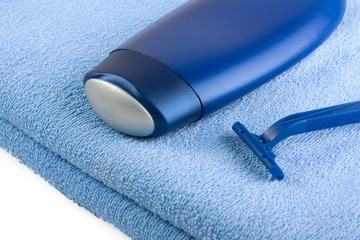 Shampoo and razor on blue towel