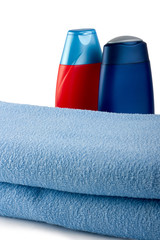 Two shampoo behind blue towel