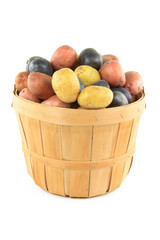 Mini potatoes with different color in wooden basket.