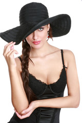 Young beautiful sexual woman in a hat and a black swimsuit