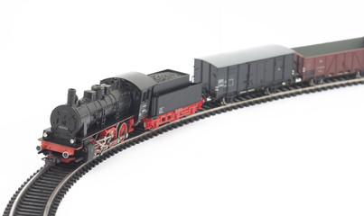 Toy steam locomotive and freight cars on white background