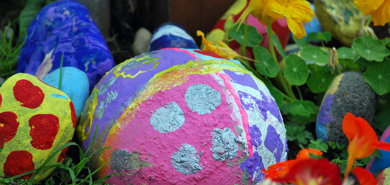 Large Painted Rocks In A Flower Garden.