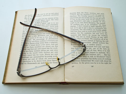 An openned book with glasses