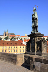 Fototapeta na wymiar Statue on the Charles Bridge with Prague Castle
