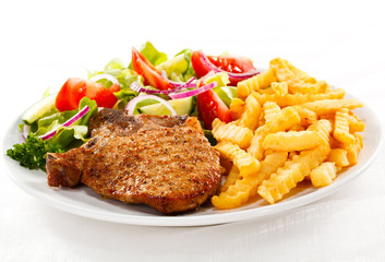 Fried pork chop with chips and vegetables