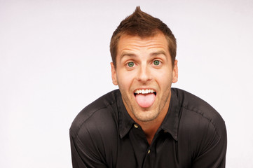 Young man in black shirt shows his tongue