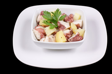 Octopus with potatoes served in a white dish