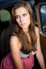 Obraz na płótnie Canvas Young brunette posing with vintage car