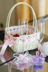 A pair of wedding glasses, basket and a ring pillow