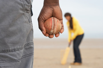 Young Couple Playing Cricket On Autumn Beach Holiday
