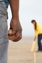 Young Couple Playing Cricket On Autumn Beach Holiday