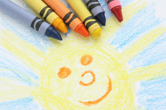 Childlike drawing of the sun and sky with crayons