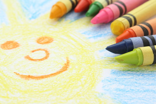 Childlike drawing of the sun and sky with crayons