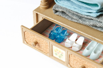 A collection of doll shoes in a drawer. Focus on the blue shoes.
