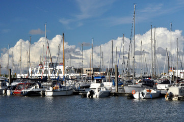Die Schiffe im Hafen von Norddeich Mole: Yachthafen belegt mit Segelschiffen und Motorbooten im Sommer. 