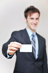 portrait of a young businessman holding blank card