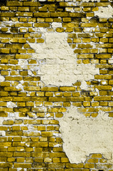 Old yellow wall with cracks and patches of plaster