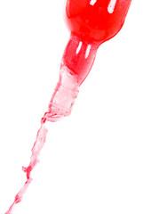 Colored water splashing on a bottle over  white