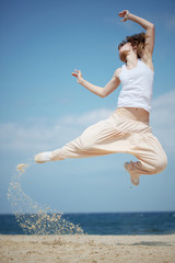 Fototapeta na wymiar Teenage dziewczyna tańczy hip-hop i skoków na plaży, seria lato
