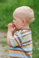 Blond child eating an apple