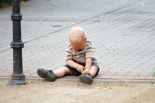 child sitting on street