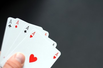hand holding four aces