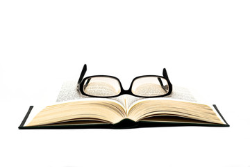 Glasses on open book isolated on white