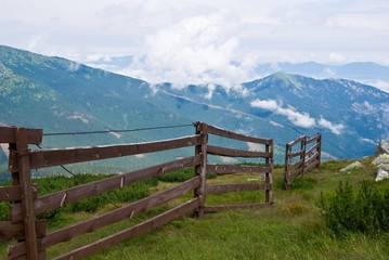 Fototapeta na wymiar wooden fence in a mountain meadow
