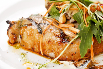 Grilled pork steak with vegetable garnish.