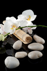 Fototapeta na wymiar Rolled bamboo mate with white orchid