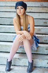 Young woman sitting on a step of abandoned building