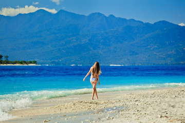 A beautiful woman wearing white bikini on a vacant beach