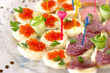 Sandwiches with salmon caviar and sausages.