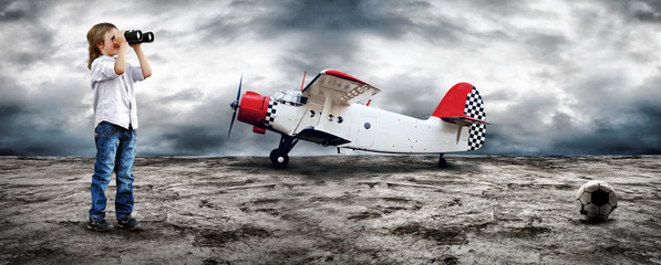 Young boy watch in the field-glass under sky