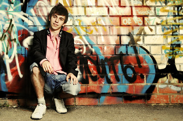 Young Guy against graffiti wall.