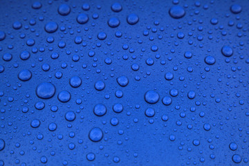 rain drops on a blue car body, shallow focus