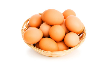 Brown eggs in the basket on white