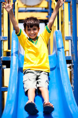 Obraz premium Young smart kid sliding down the swing