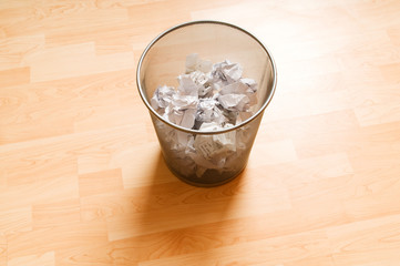 Garbage bin with paper waste isolated on white