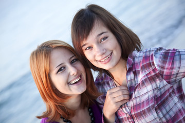 Obraz premium Closeup portrait of two happy girls on the beach