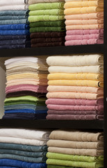 New fluffy towels on a rack in shop