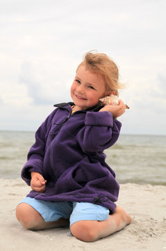 Am Strand mit einem Muscheltelefon :-)
