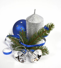 Silver candle with the twig of the spruce and bells