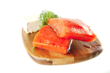 smoked salmon on wooden plate with white cheese